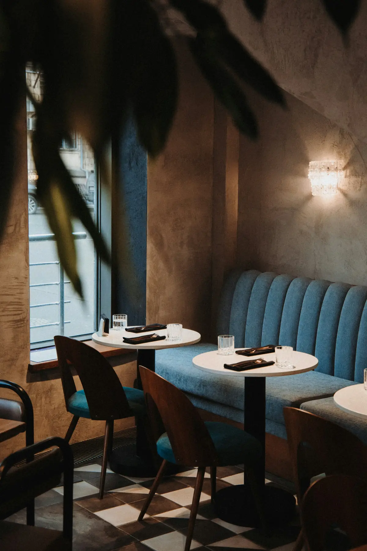 The dim dining room with banquettes and warm lamps