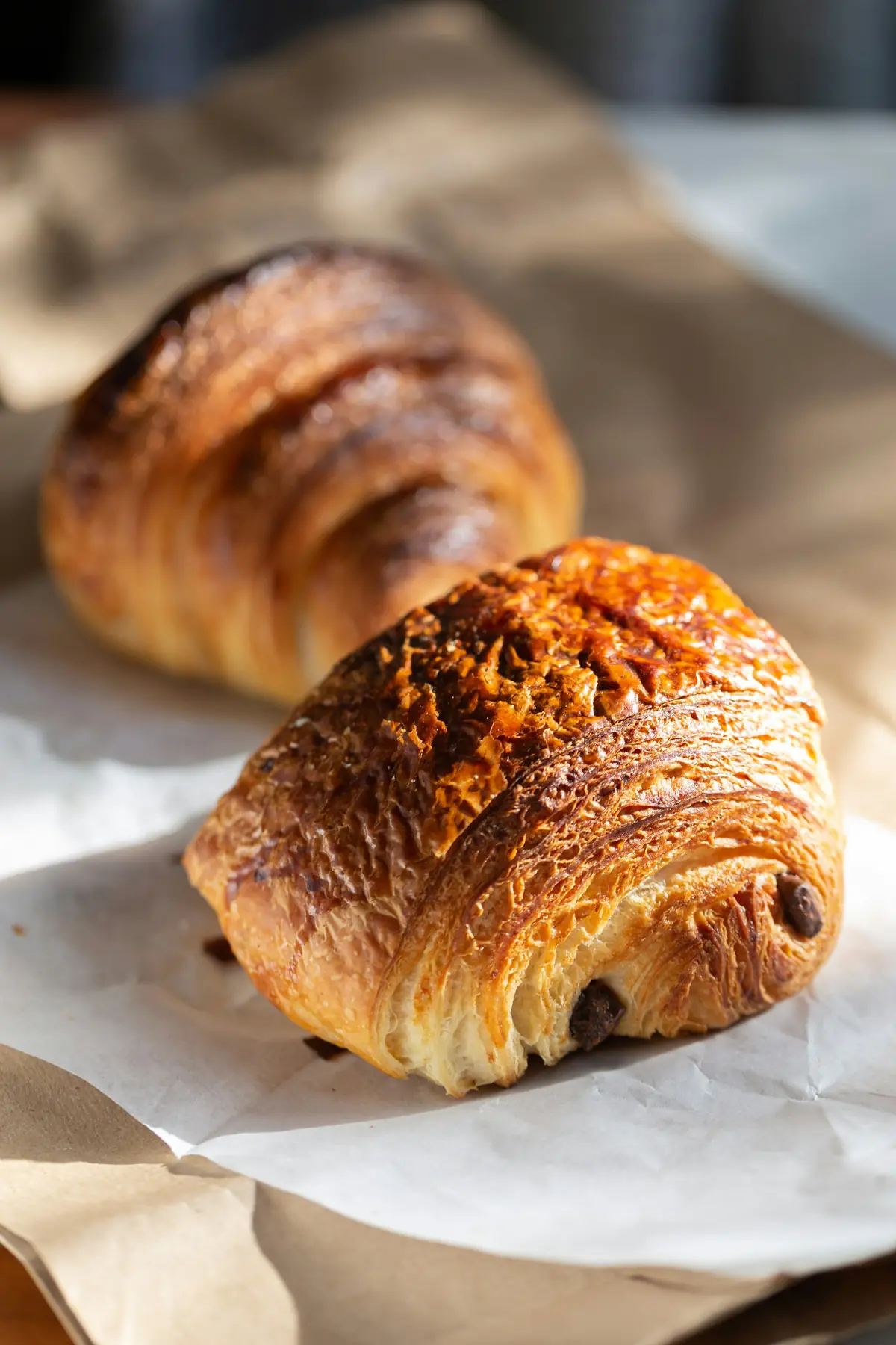 A croissant and a pain au chocolat on paper